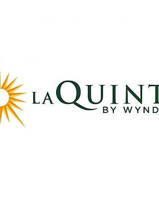 The image shows the logo of La Quinta by Wyndham, featuring a stylized sunburst next to the brand name text.